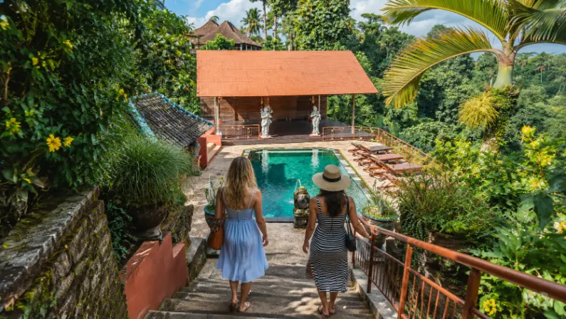Two women walking towards the shala at tanah merah art resort facilities for wellness